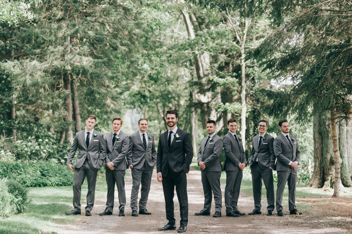 Groom and groomsmen in grey attire posing for classic portraits