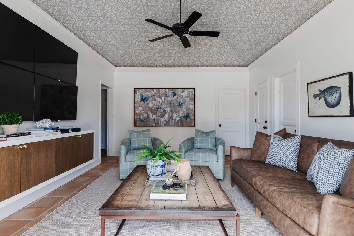 oyster creek studios home on the range wooden coffee table with brown sofa and blue armchairs in living room