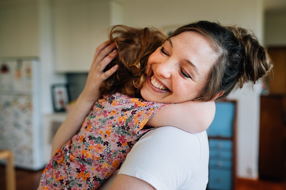 Mum holding girl and cuddling in home during Melbourne maternity photography session.