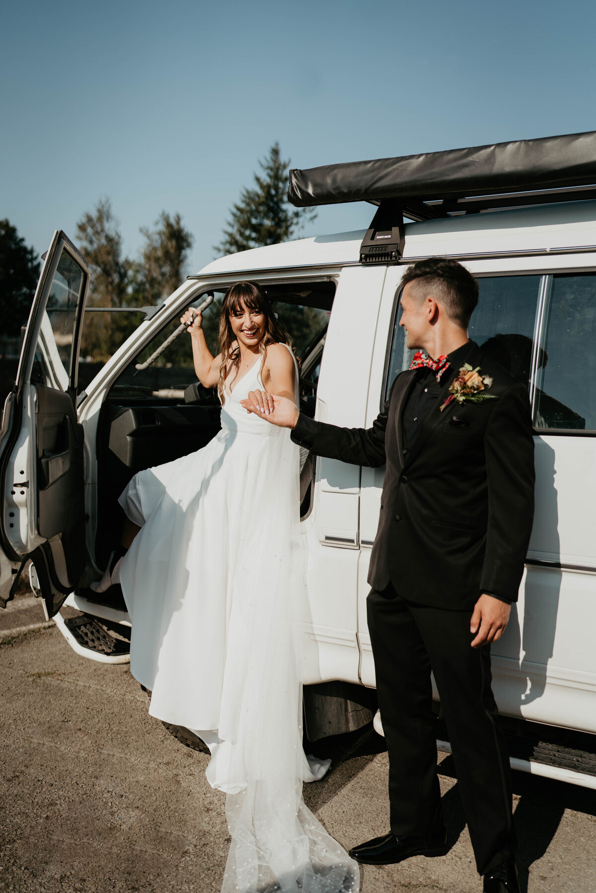 Groom helping bride out of sprinter van before Columbia River Gorge wedding