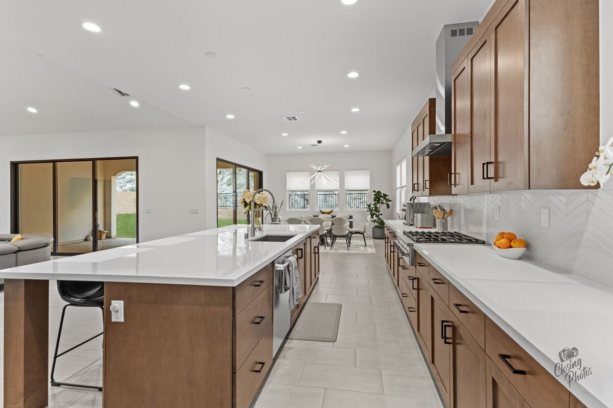 Modern and bright kitchen with dark wood cabinets and white countertops.