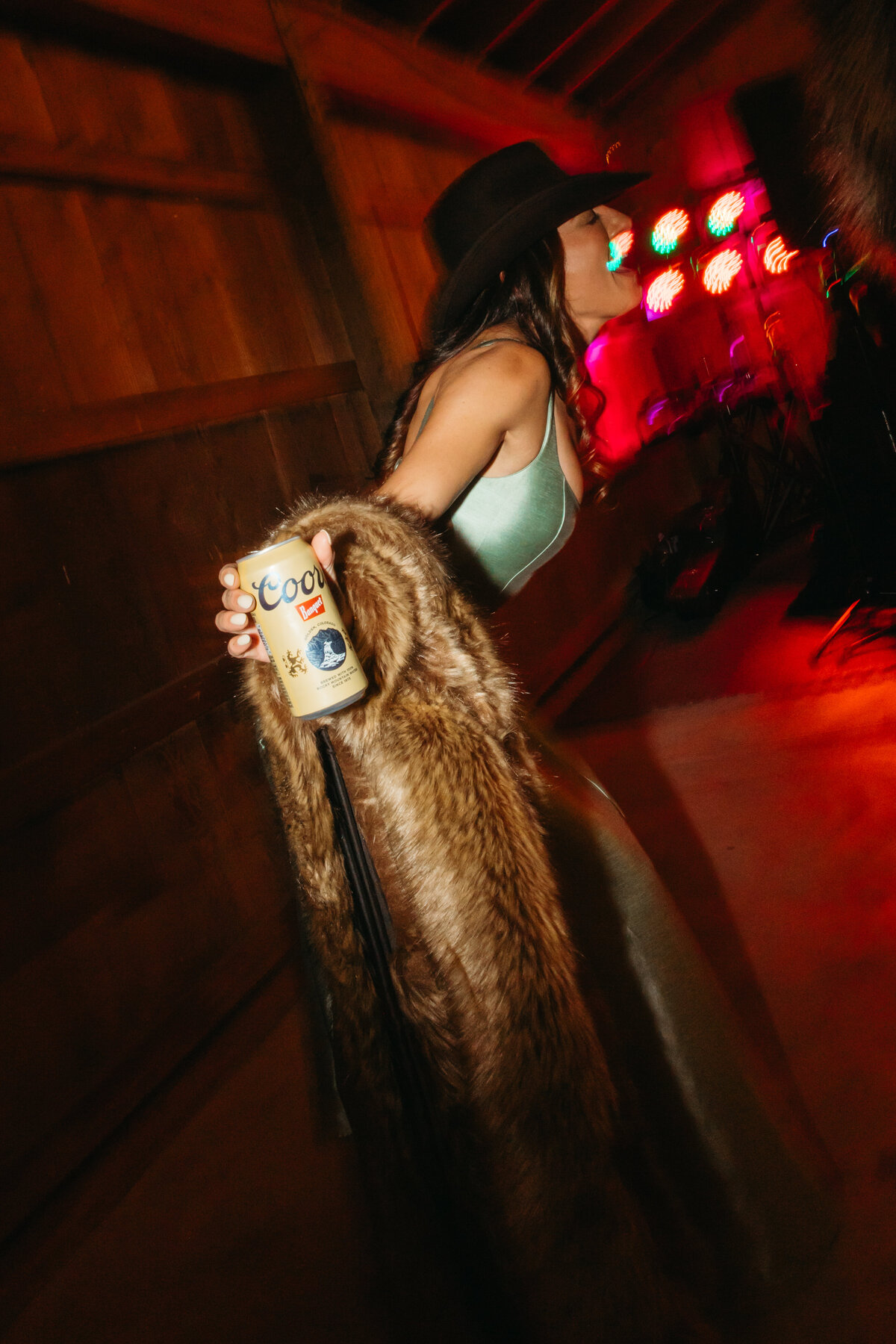 wedding guest in fur dances with beer