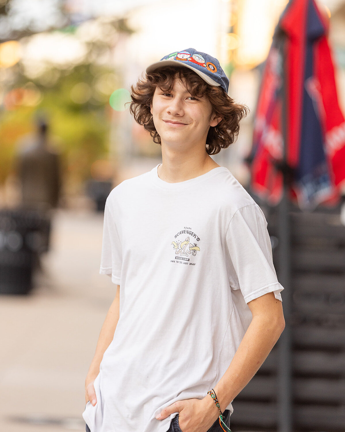 senior boy relaxed with hand in pocket downtown urban smiling