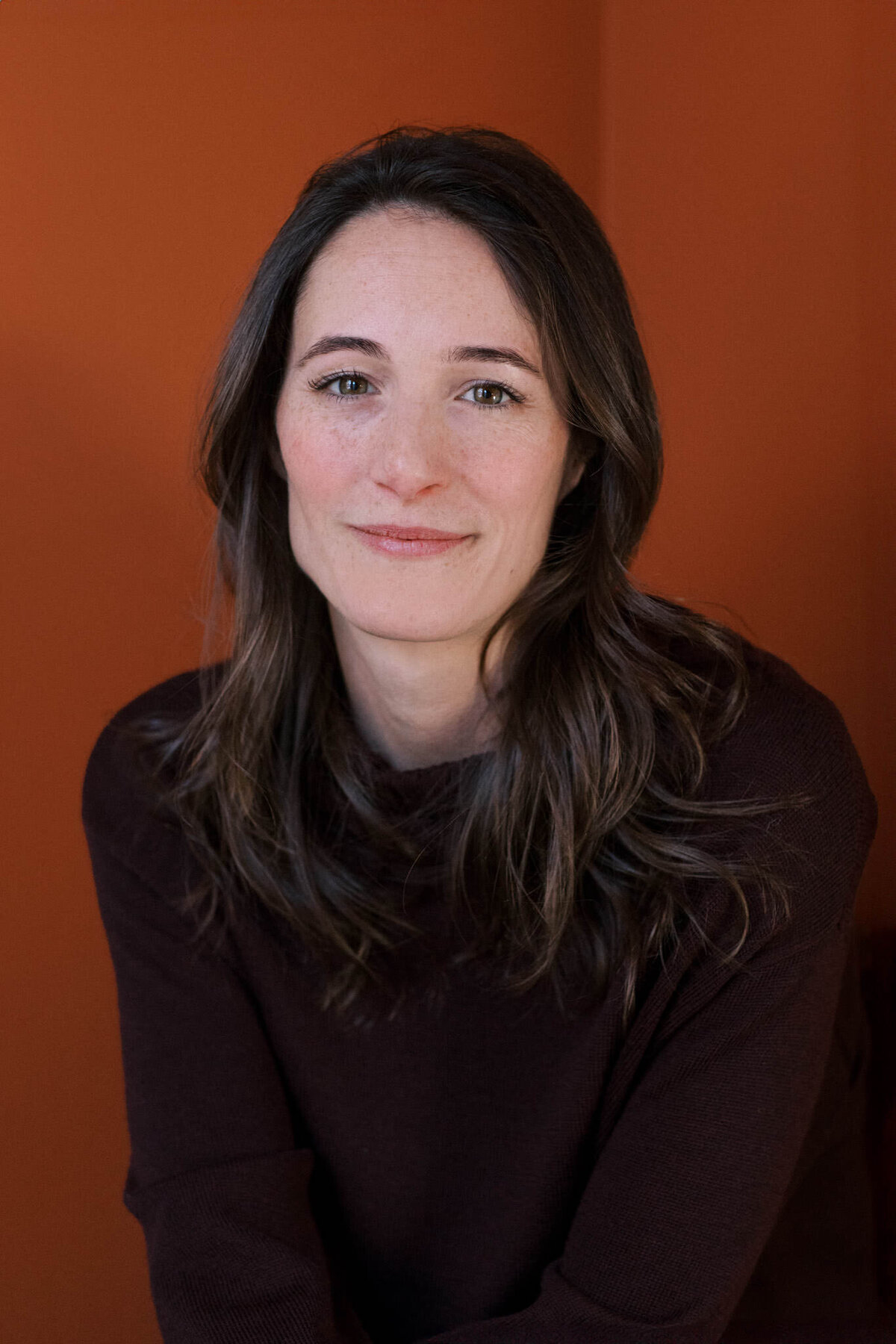 portrait of author flynn berry against an orange backdrop