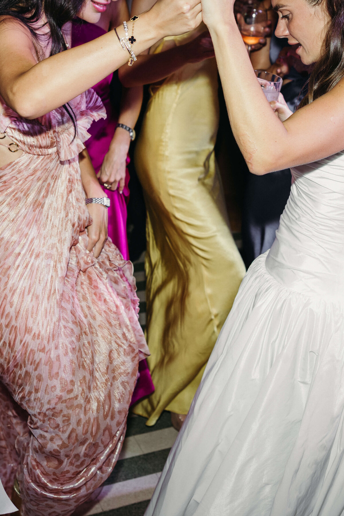 Bride dancing in white dress surrounded by joyful guests

