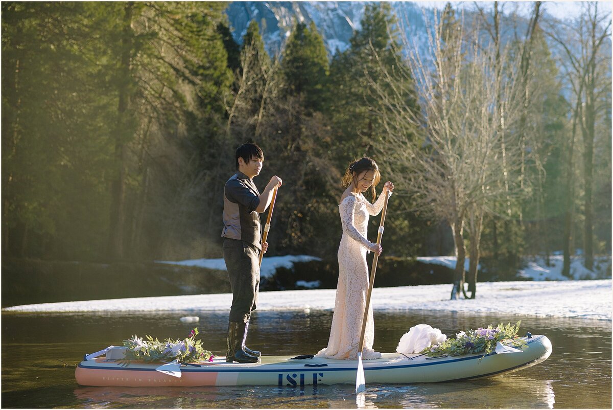 Bride and groom paddle board during their Yosemite Elopement