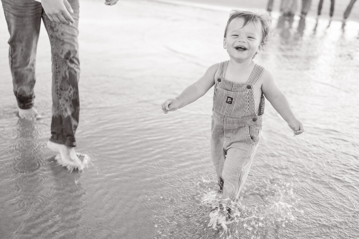 black-and-white-family-photo-boy-running-on-beach