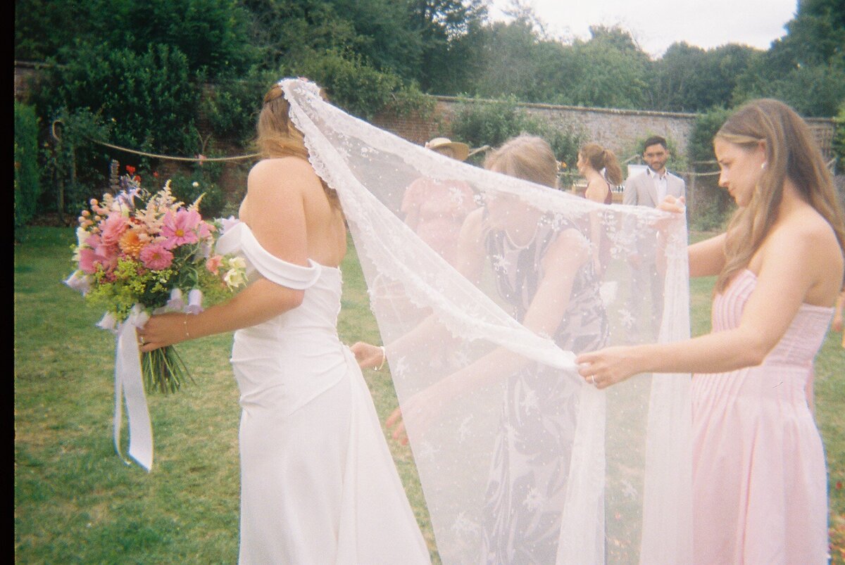 Bridesmaids helping the bride with her veil