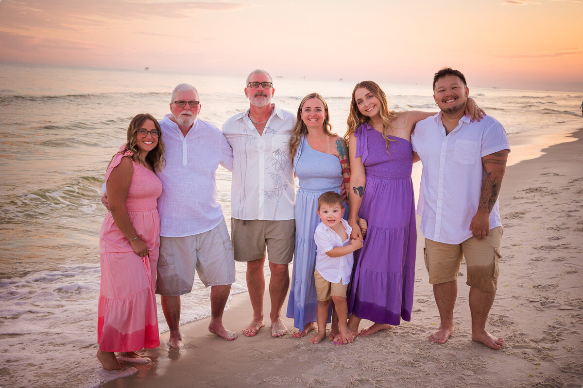 Family in standing on shoreline during golden hour