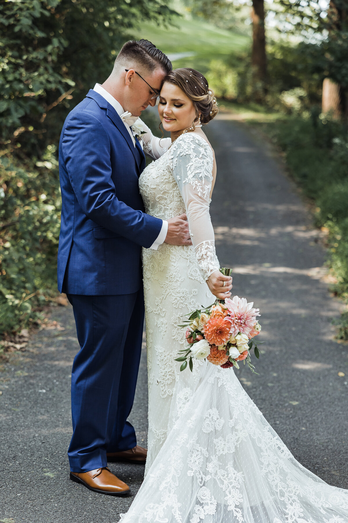 bride and groom standing together touching heads