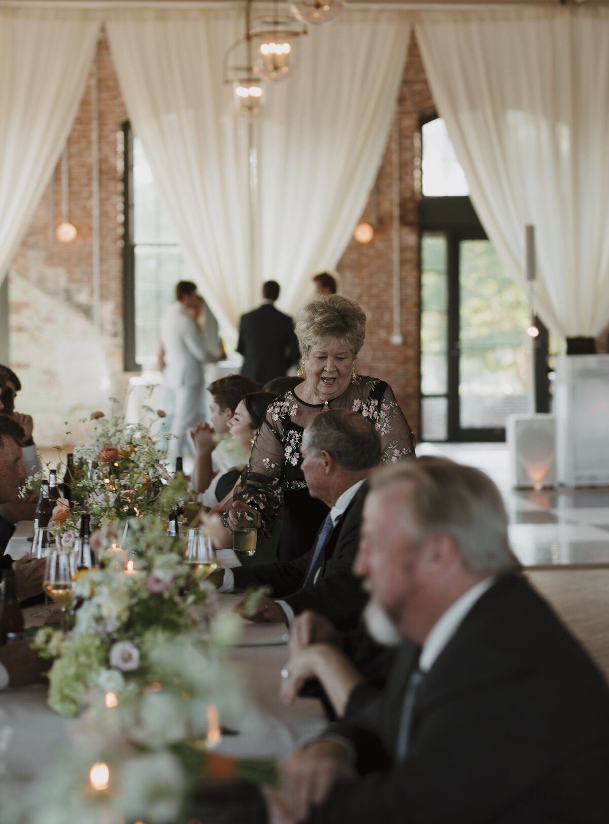 guests laughing and chatting at dinner table