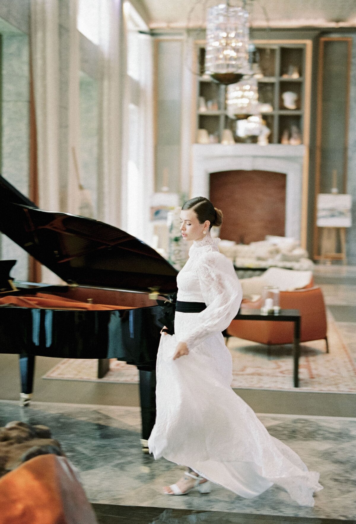 bride-walks-through-marble-hotel-lobby-past-piano