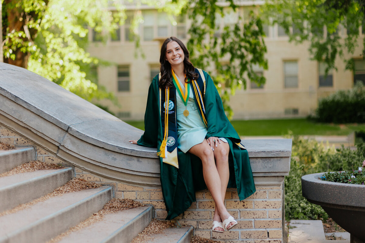 In front of the iconic Administration Building at Colorado State University, a graduate poses for a photo during her senior grad session.