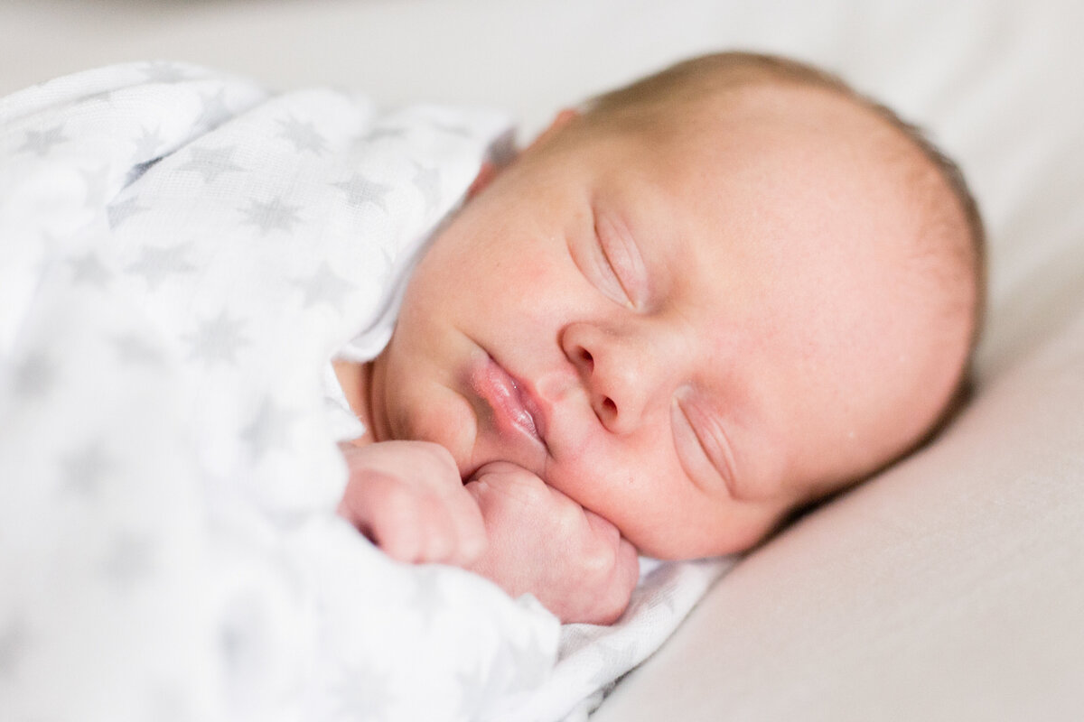 newborn baby smashes cheeks while sleeping