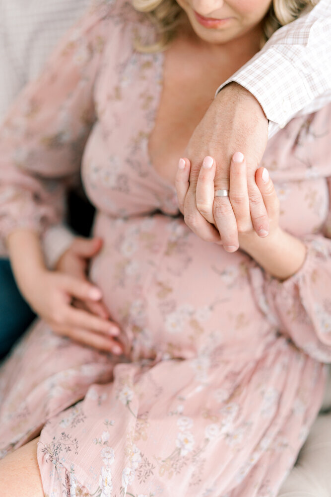 close-up-of-husband-and-wifes-hands-over-pregnant-belly