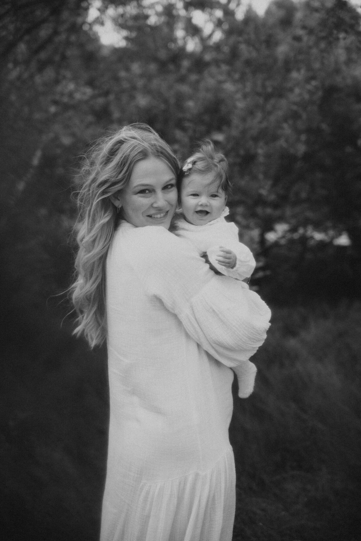 Mama houdt dochter vast in grasveld tijdens familie fotoshoot in Antwerpen
