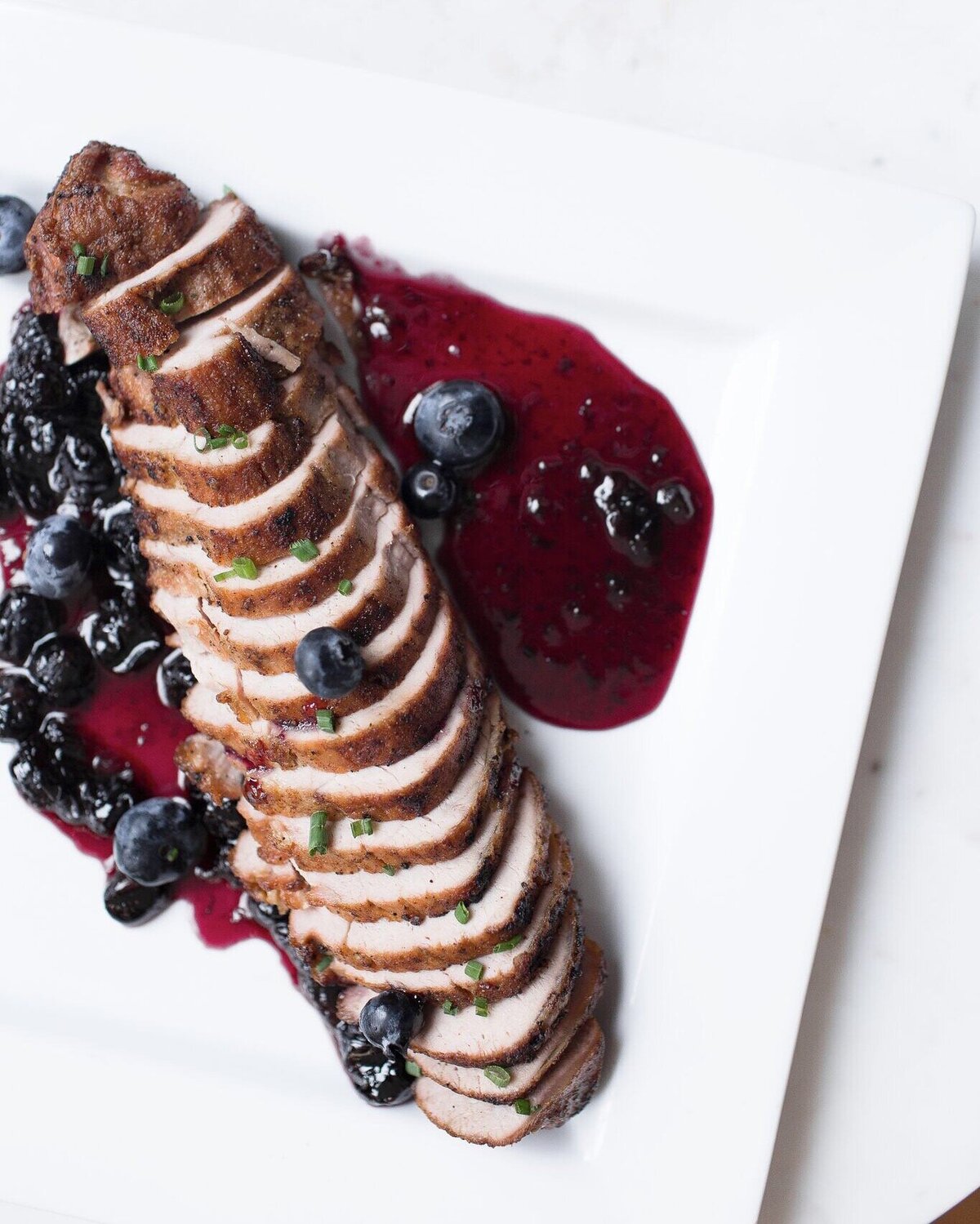 brown sugar brined pork tenderloin with blueberry pan sauce served on a family style platter at Willowbrook wedding venue in Pittsburgh