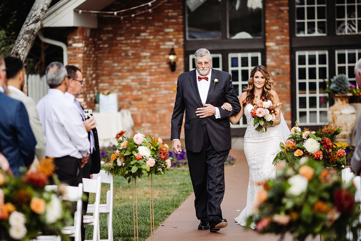 Bride walks down the aisle with her father.