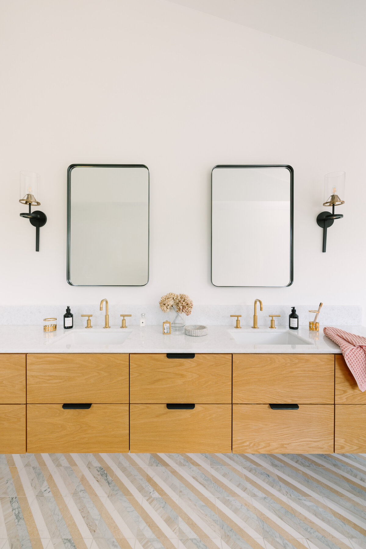 Primary bathroom with floating oak vanity, chevron marble flooring