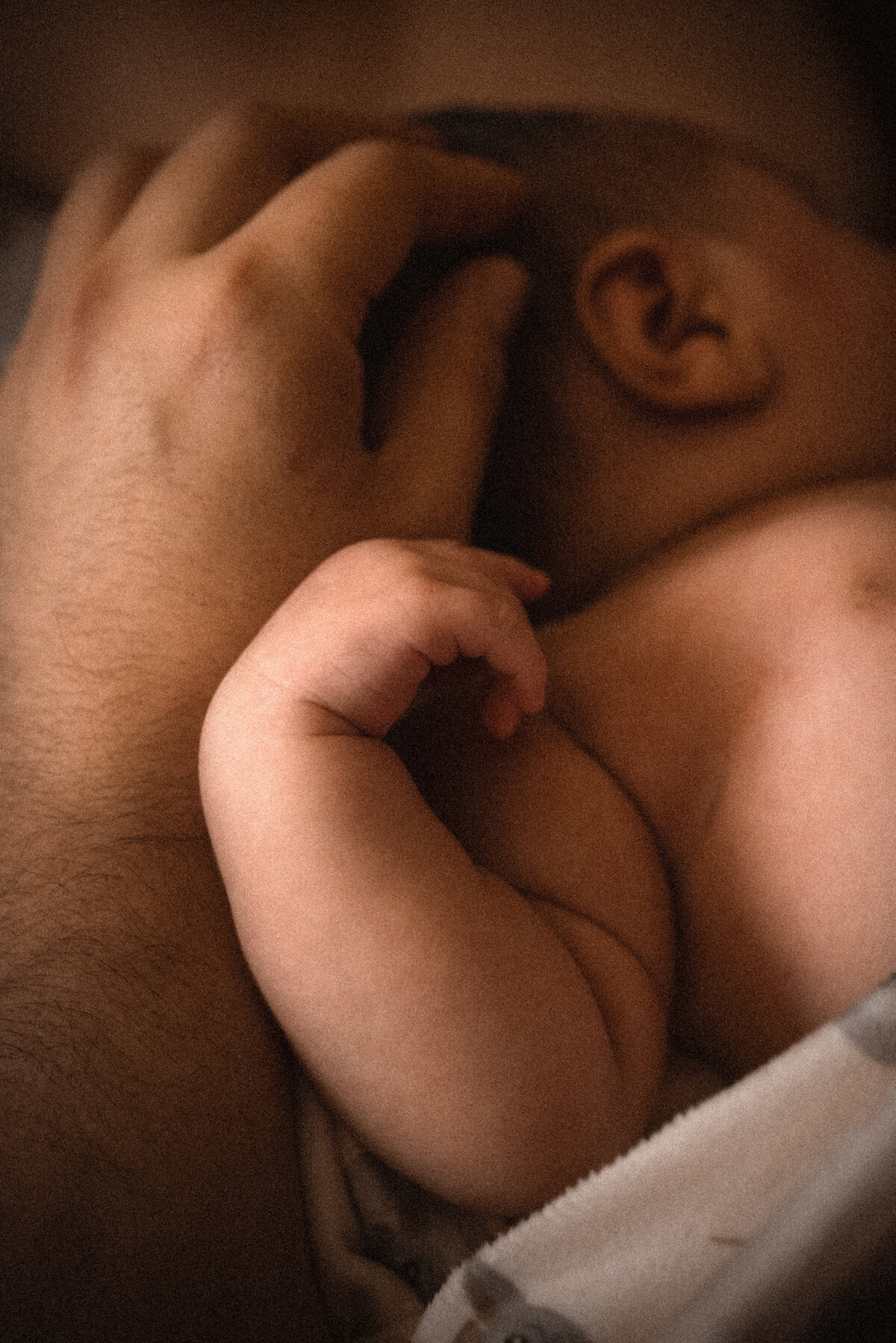 Newborn baby hand on father's hand