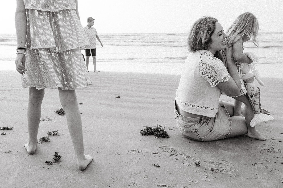 Black and white family portrait on the beach, captured by Sara James, a San Antonio family photographer.