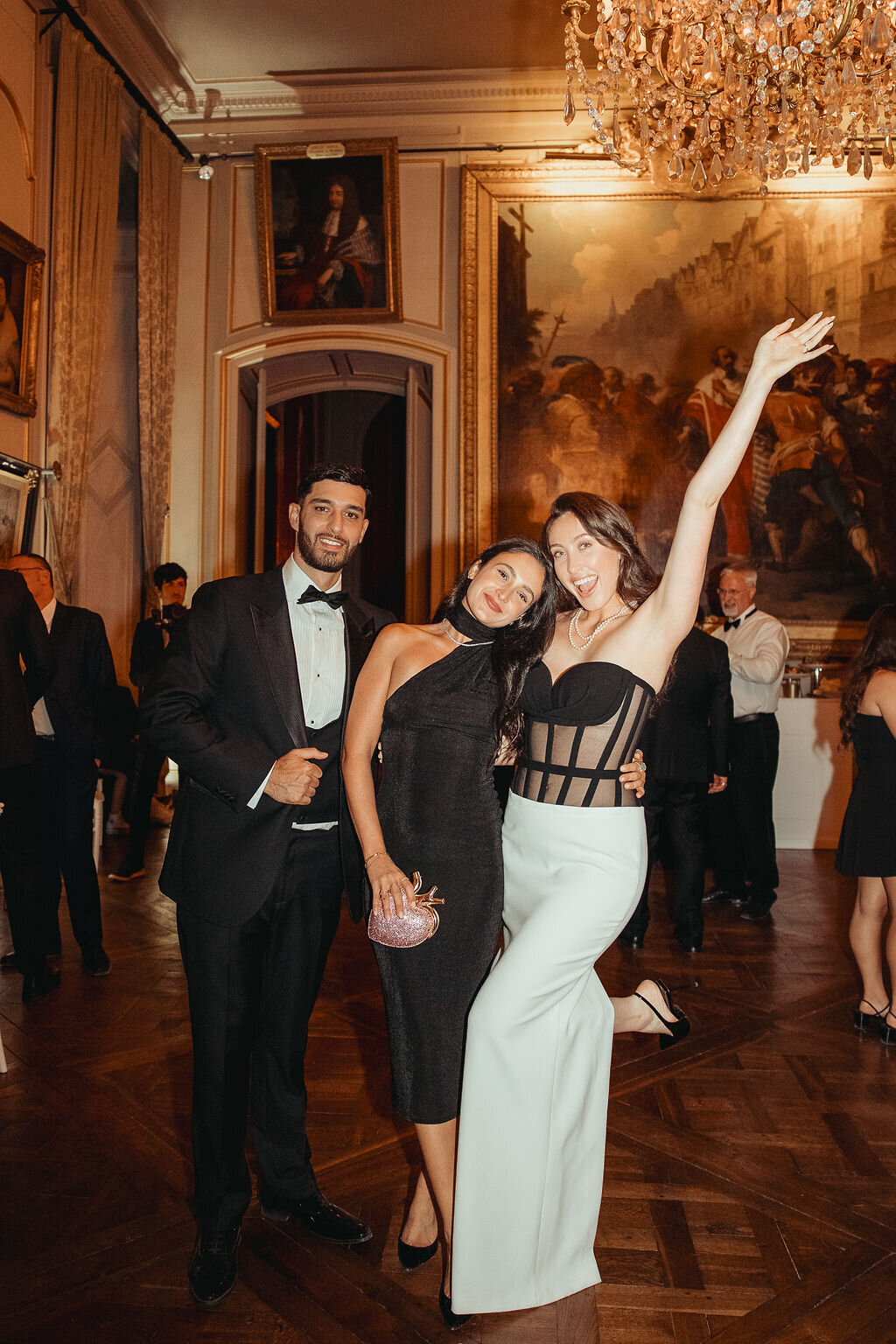 bride and groom and a guest celebrating during cocktail hour