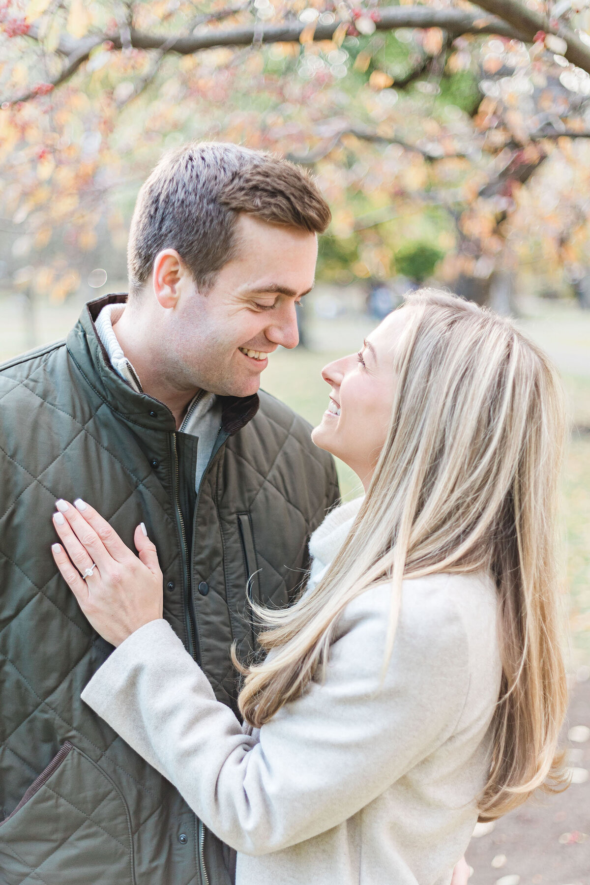 A portrait of an engaged couple as the bride to be shows off her ring