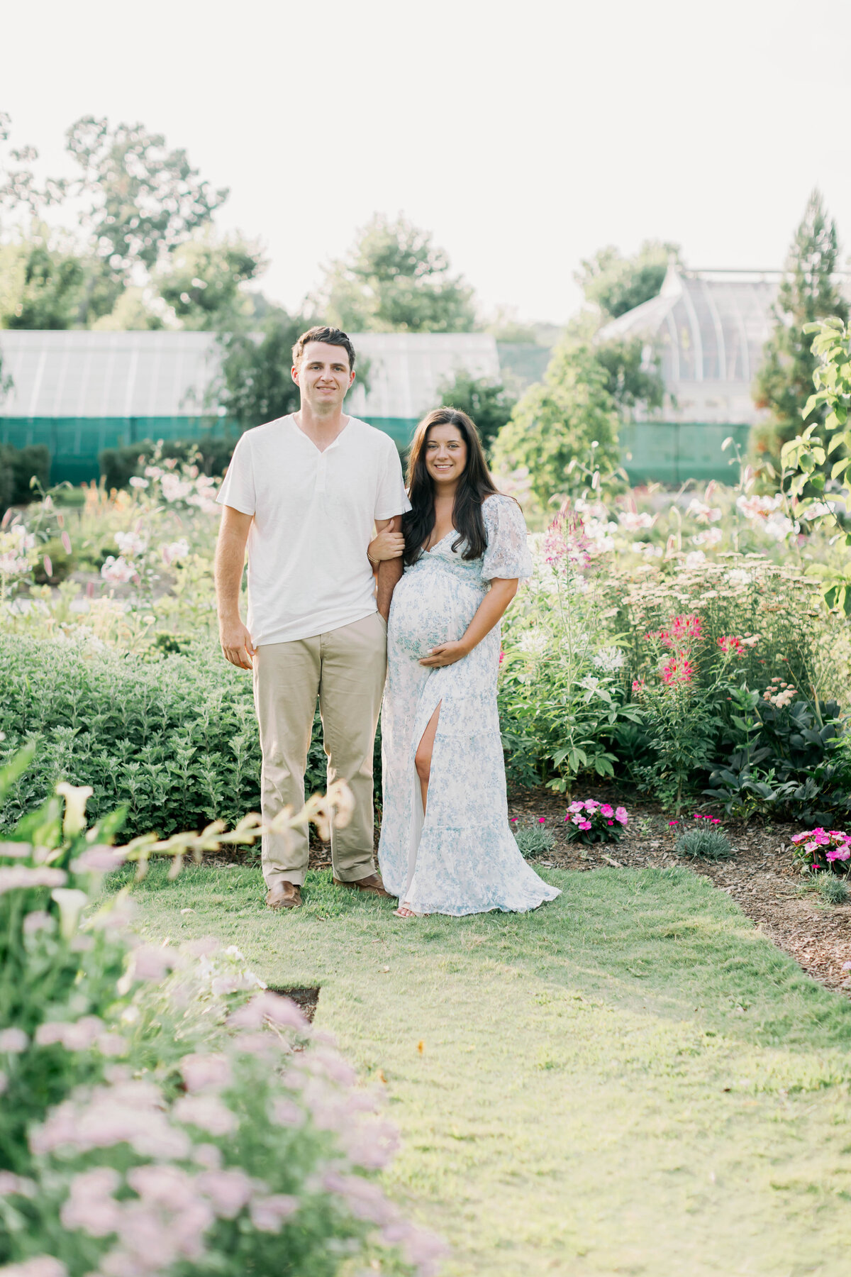 pregnant mom and husband in a flower garden