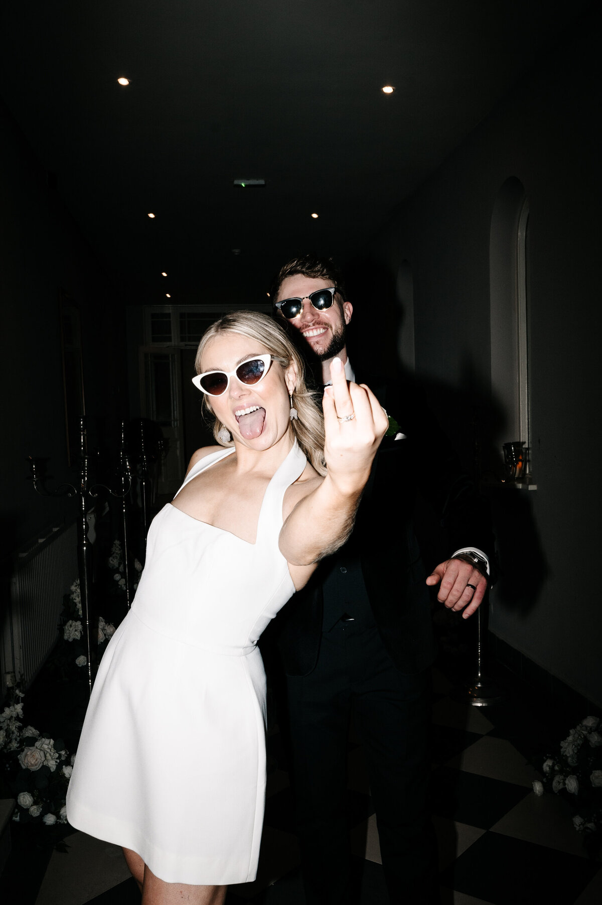 Bride and groom smiling with sunglasses on showing off their wedding rings