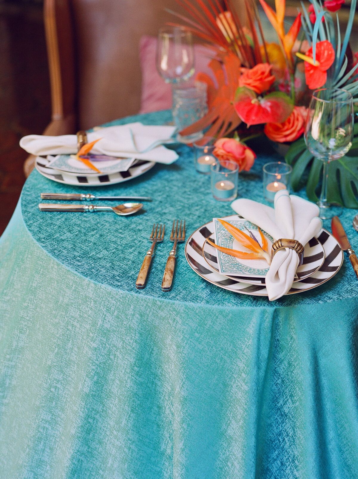 A gorgeous blue tablecloth with a tropical setting and florals.