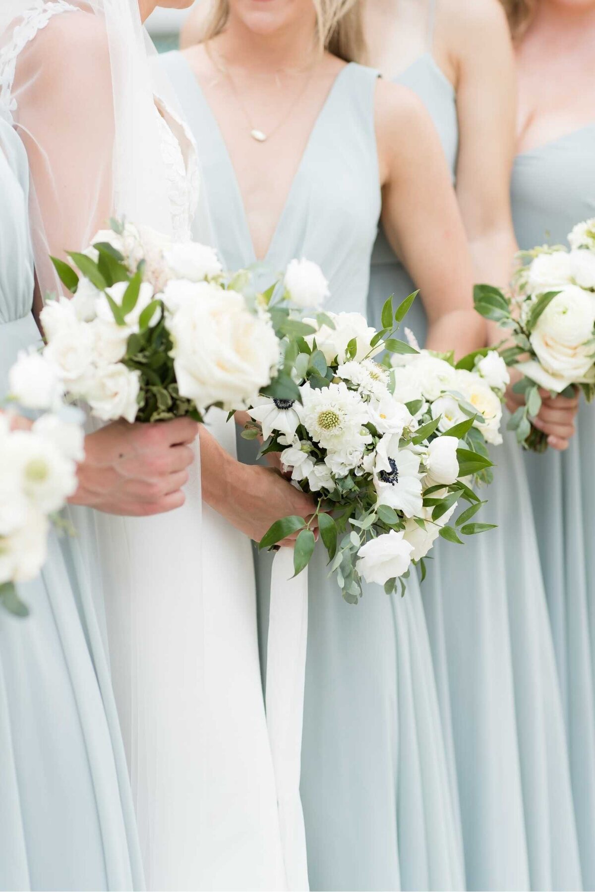 Bride and bridesmaids lush garden bouquets with white and green floral and light blue green dresses at a Luxury Chicago Outdoor Historic Wedding Venue.