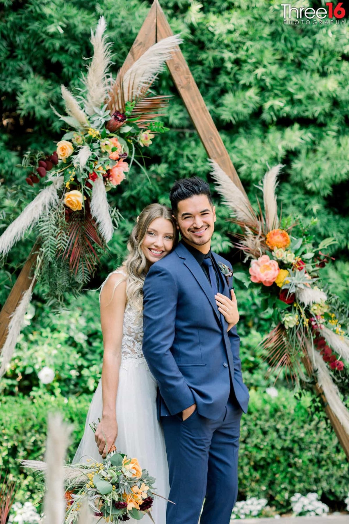 Bride holds her Groom from behind as they both smile during the photo shoot