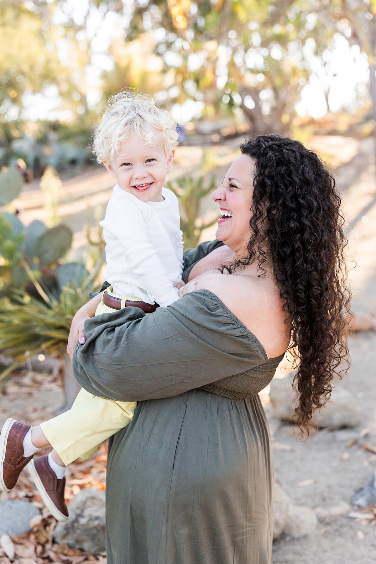 mother holding young son and laughing