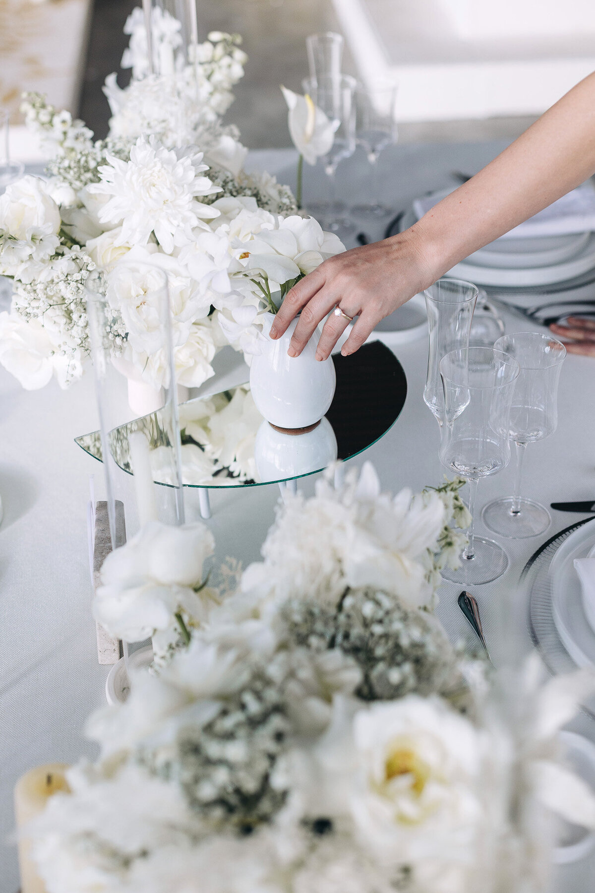 White Whisper wedding centerpieces featuring orchids and baby’s breath in luxury Tuscan setting