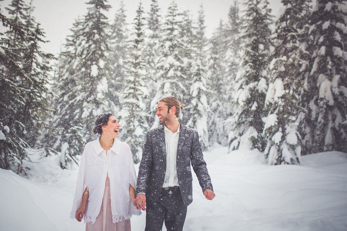 Wedding photos in the snow on top of a mountain.
