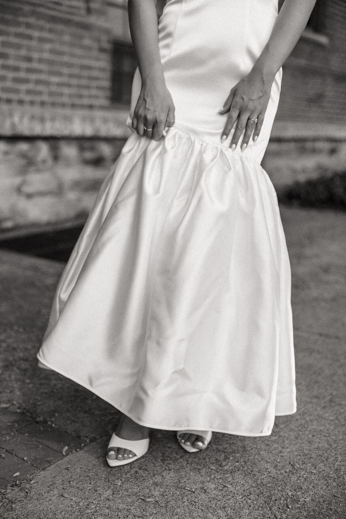 Black-and-white detail of bride’s satin gown and open-toe heels during a Philadelphia wedding shoot.