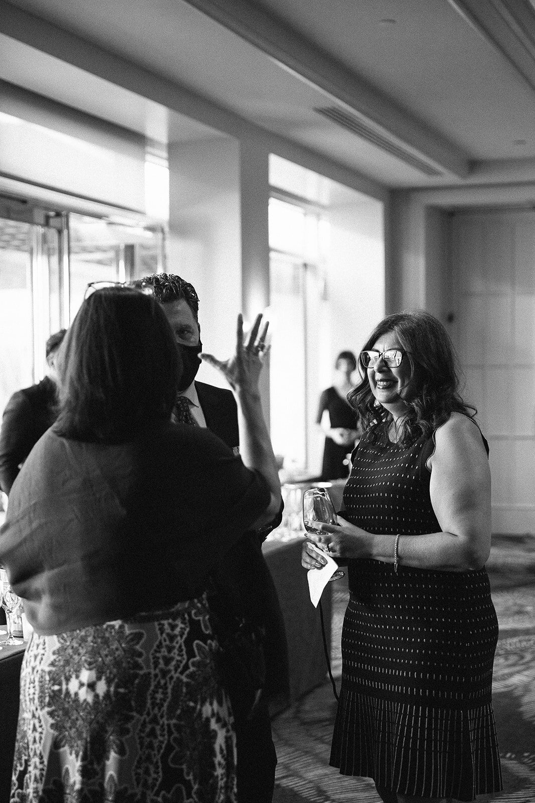 group photo of people mingling while holding a glass of wine 