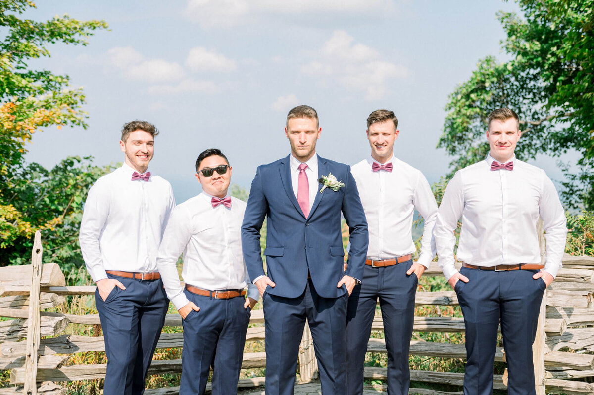 Groom standing in the middle of groomsmen looking at Toronto wedding photographer
