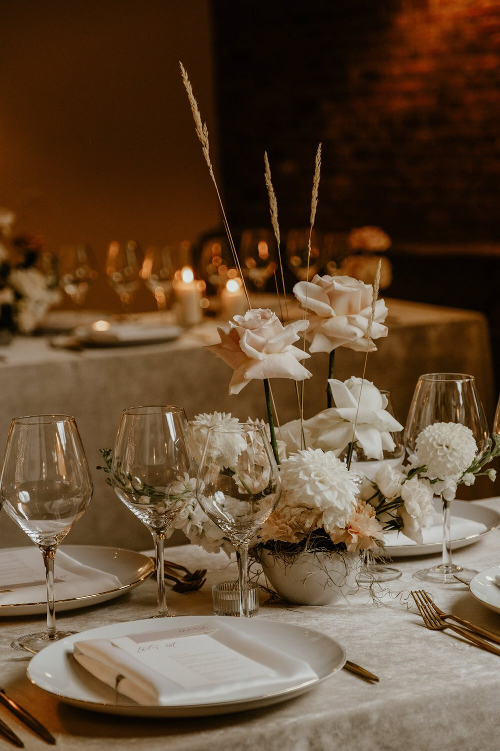 Elegant floral centrepieces of lush white flowers at a wedding reception at Entrepot Dominion.