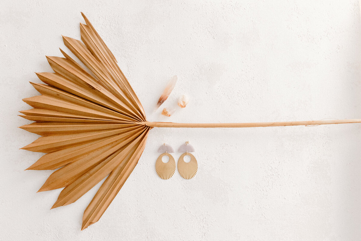 orange palm leaf with handmade earrings and crystals