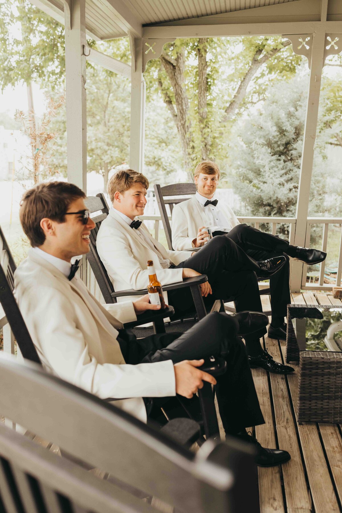groomsmen sit and chat on the patio before the big ceremony