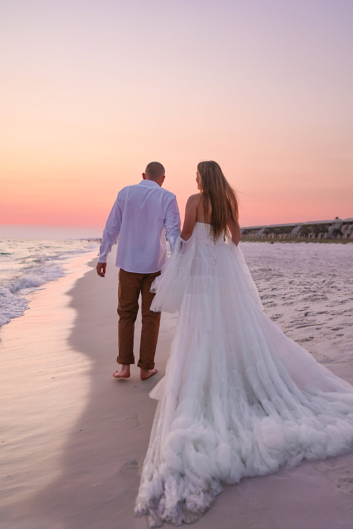 bride and groom holding hands walking on beach in Panama City Beach Florida by Panama City Beach elopement photographer Amanda Richardson Photography