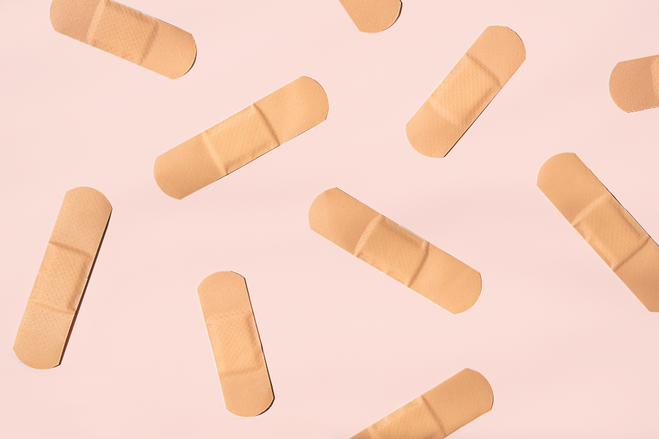 biege band-aids against a pink background