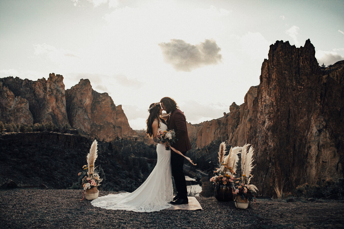Couple holds each other with views of Smith Rock in the background