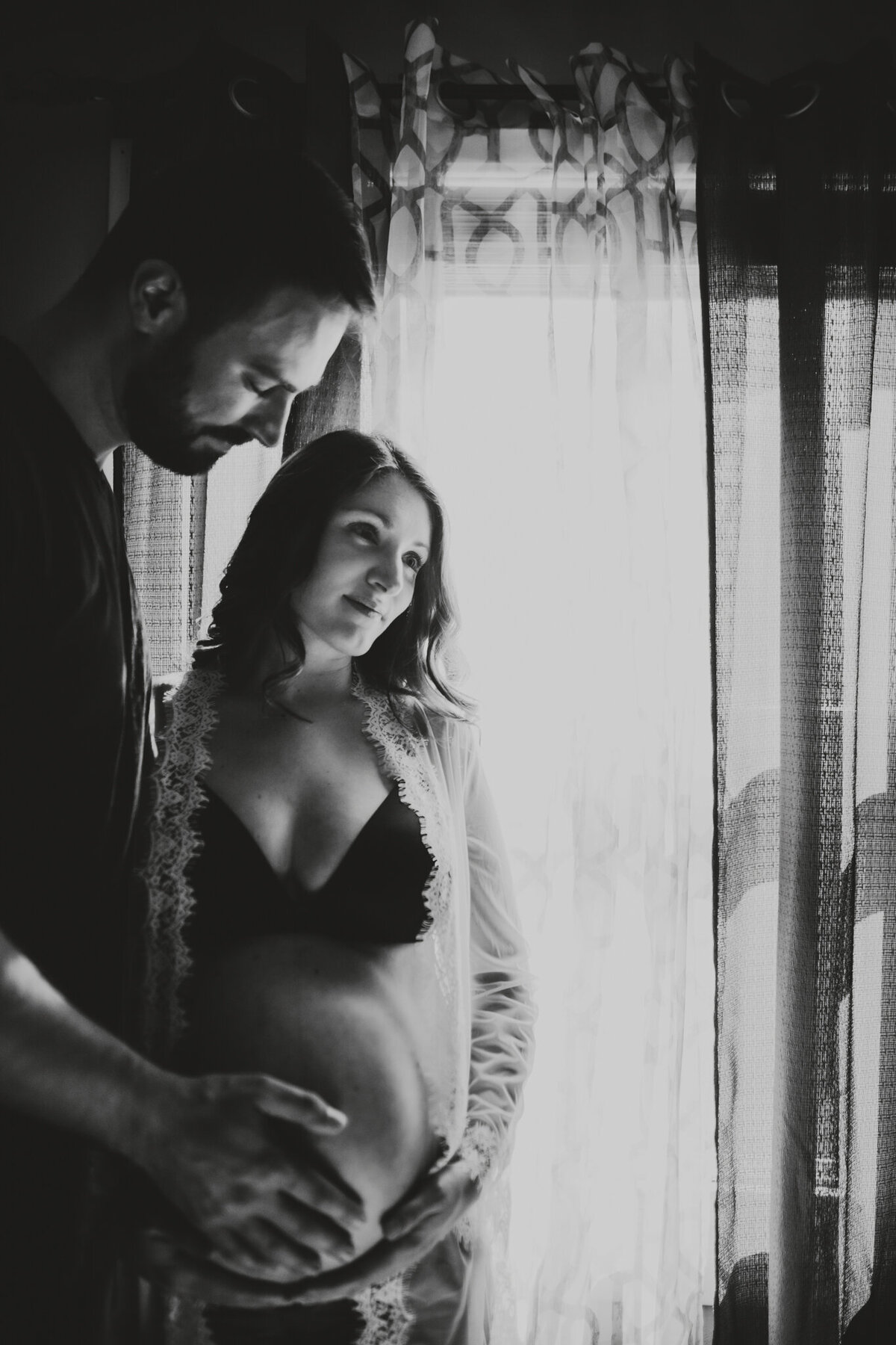 black and white maternity photo of mom and dad pregnant belly
