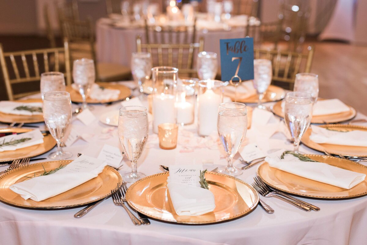Wedding place setting with  gold plates candles and glasses