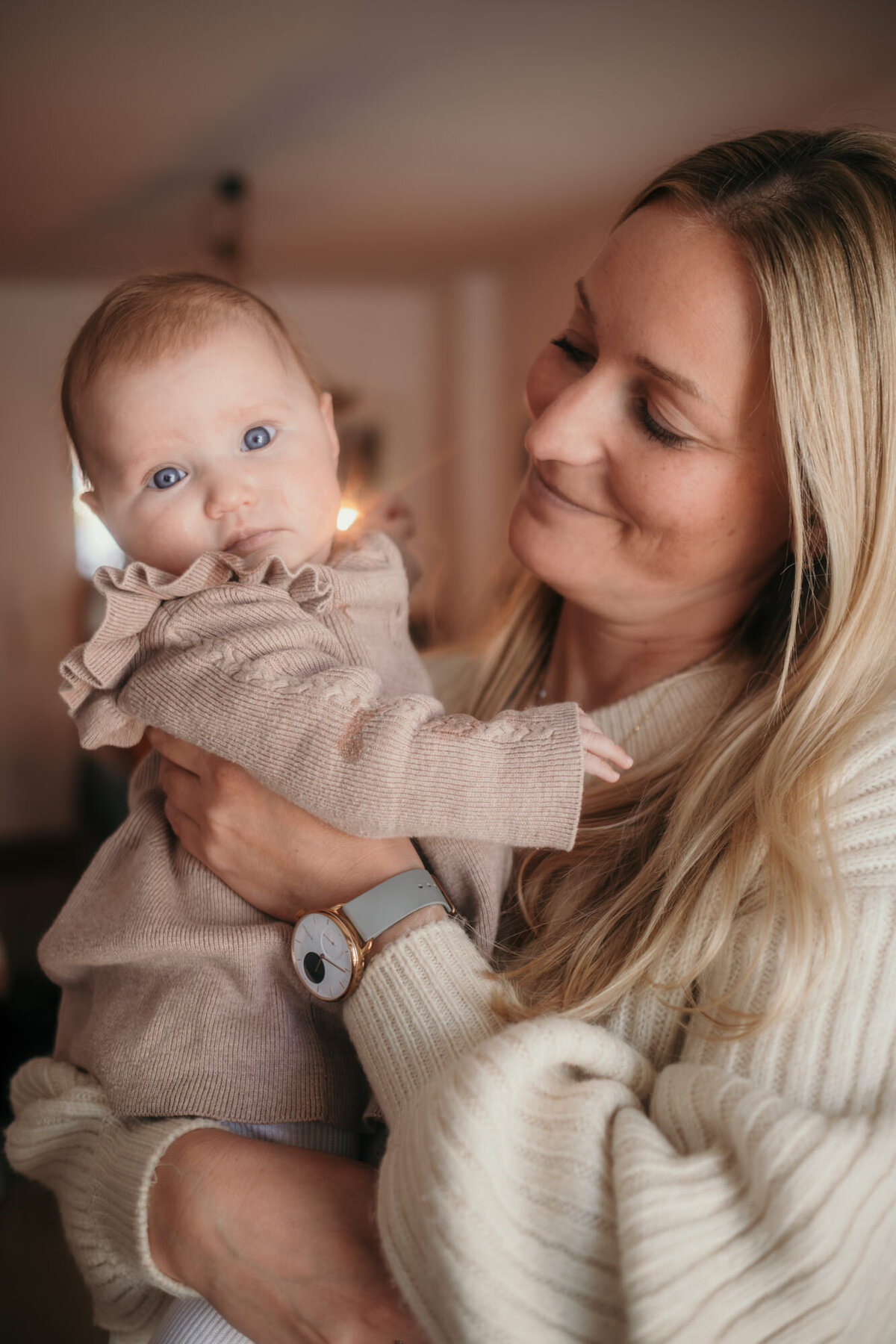 Mom holds baby, who is looking curiously at the camera.