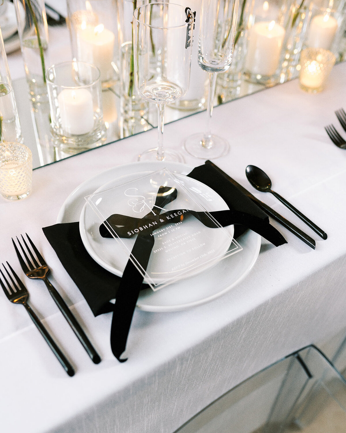 A table setting featuring a plate, silverware, and a clear acrylic menu.