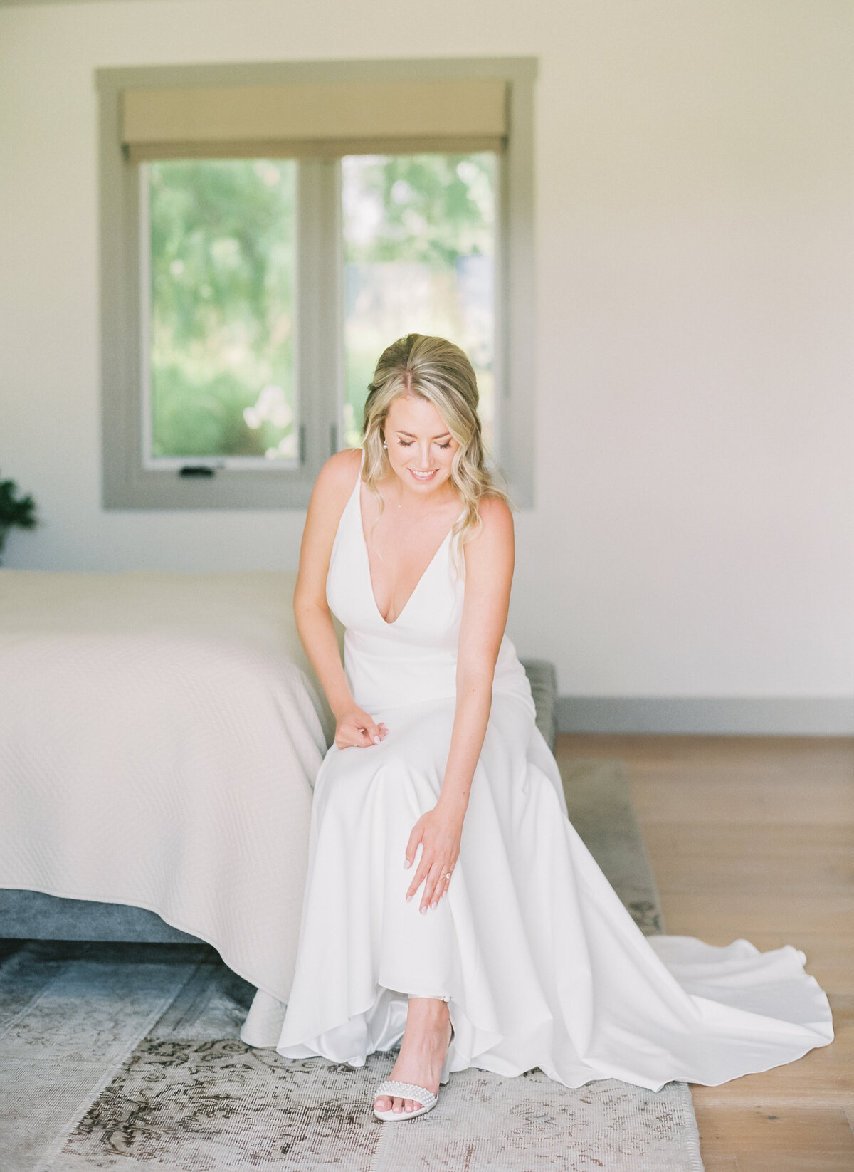 bride putting on wedding heels inside