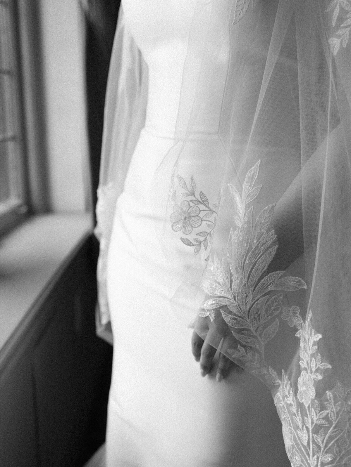 black and white up close of the brides hand resting at her side with her veil  over top taken by Mansfield Wedding Photographer, Annie Trammel
